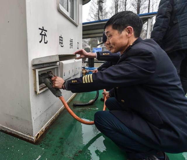 1月18日，工作人員在為純電動(dòng)貨運(yùn)船插上充電線。該電動(dòng)貨運(yùn)船一次充電可以行駛200至300公里，充電時(shí)間大約6至8小時(shí)。
